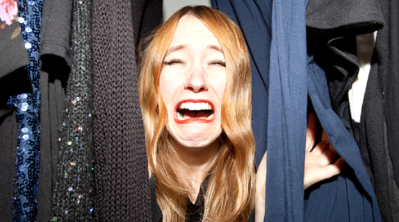 woman looking at clothes and crying