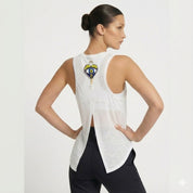 Woman wearing a white tank top with a colorful design on the back against a light gray background