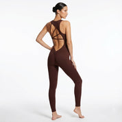 Woman wearing a brown open-back jumpsuit on a white background