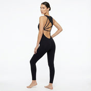 Woman wearing a black strappy jumpsuit on a white background