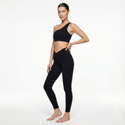 Woman wearing a black sports bra and leggings on a white background