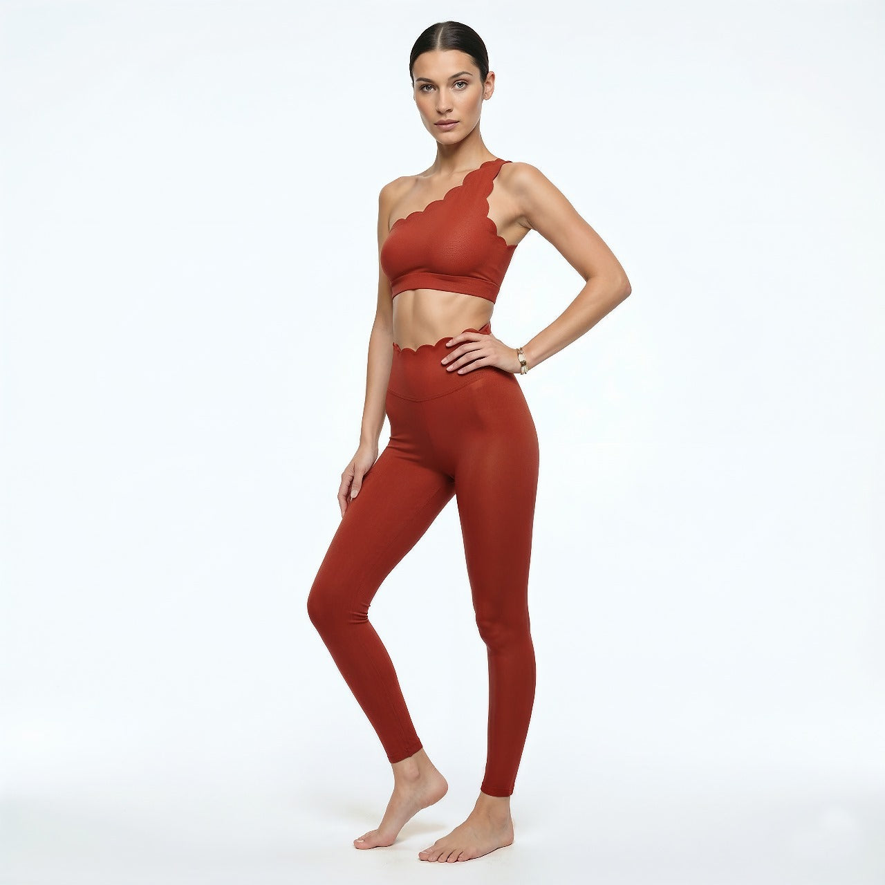 Woman wearing a red sports bra and leggings on a white background