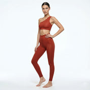 Woman wearing a red sports bra and leggings on a white background