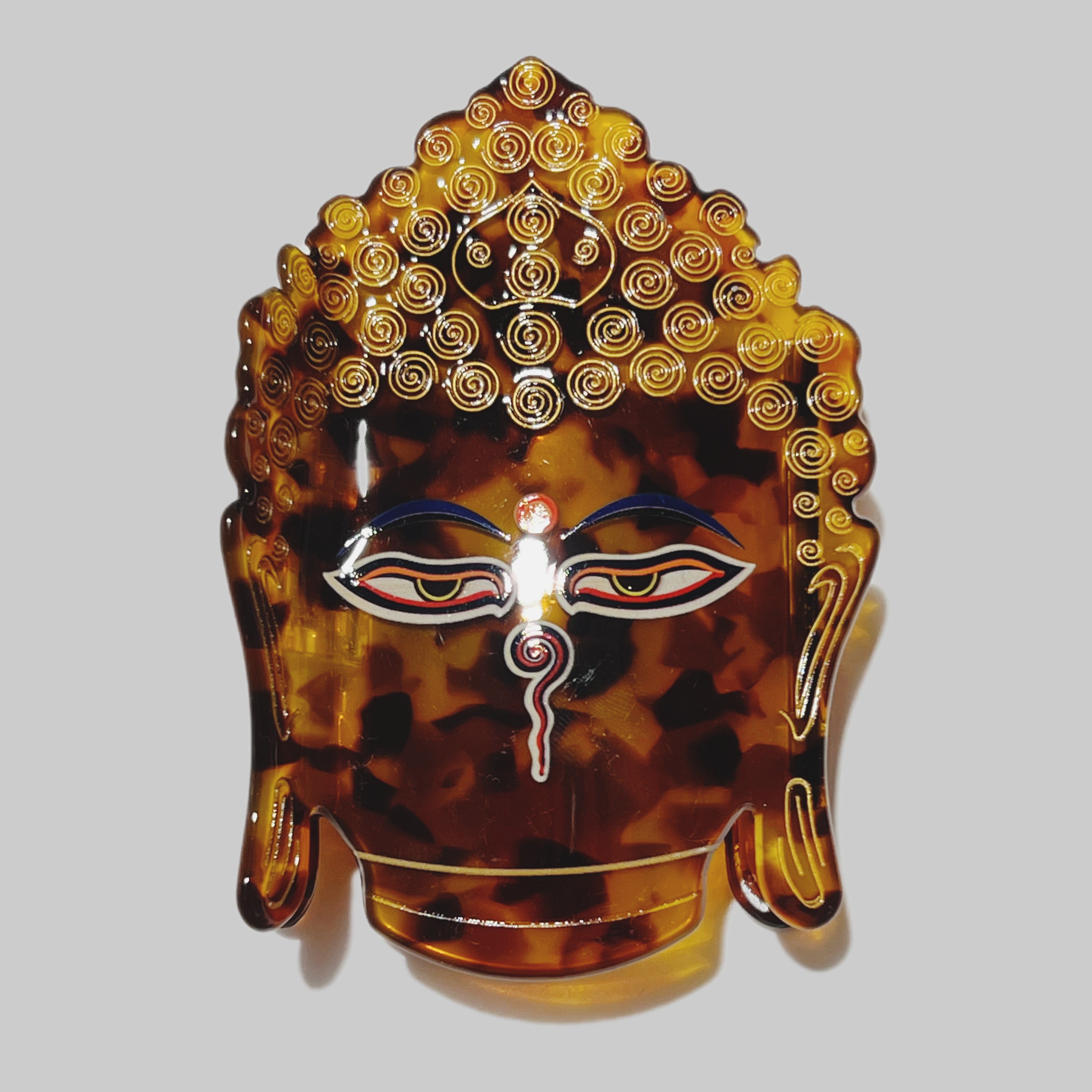 Tortoiseshell Buddha head with intricate design on a white background