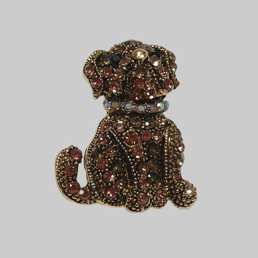 Decorative brooch shaped like a dog with gemstone details on a gray background