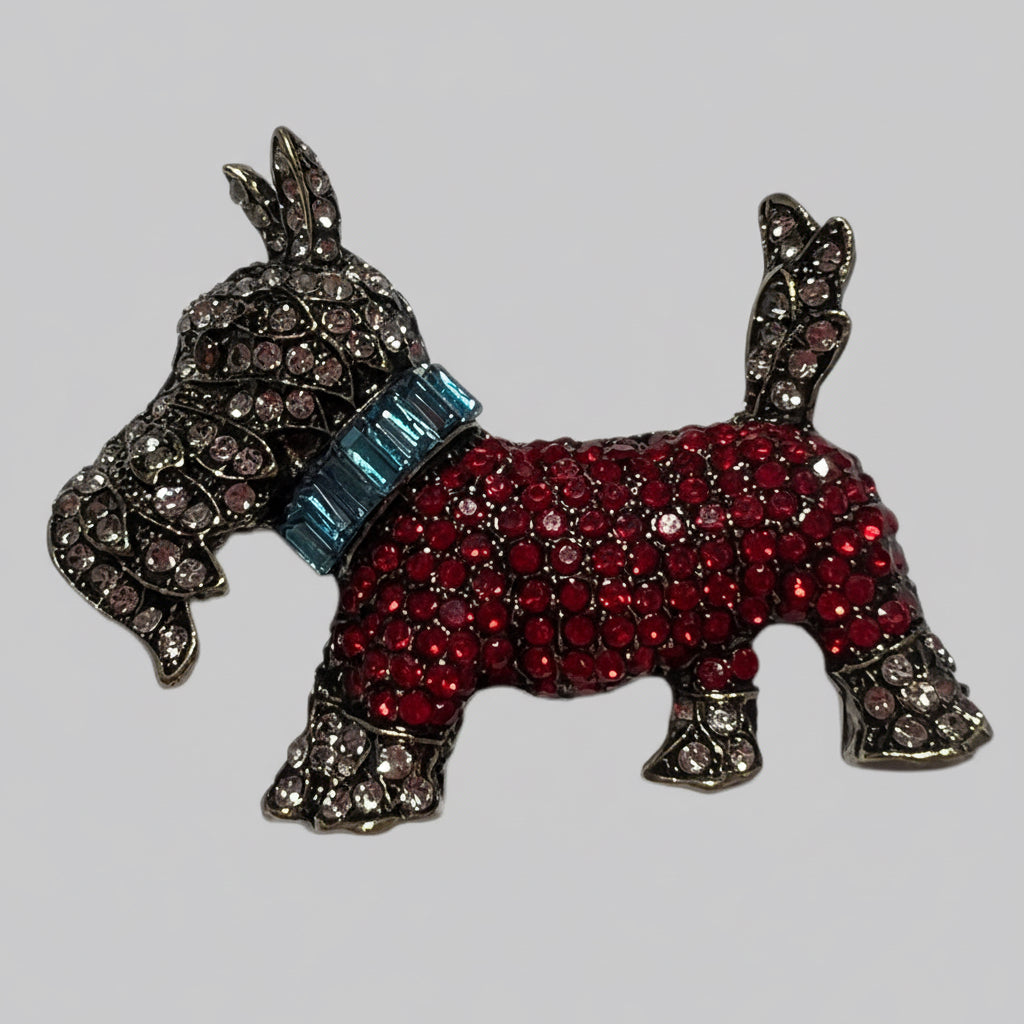 Dog-shaped brooch with red body, blue collar, and silver accents on a light gray background