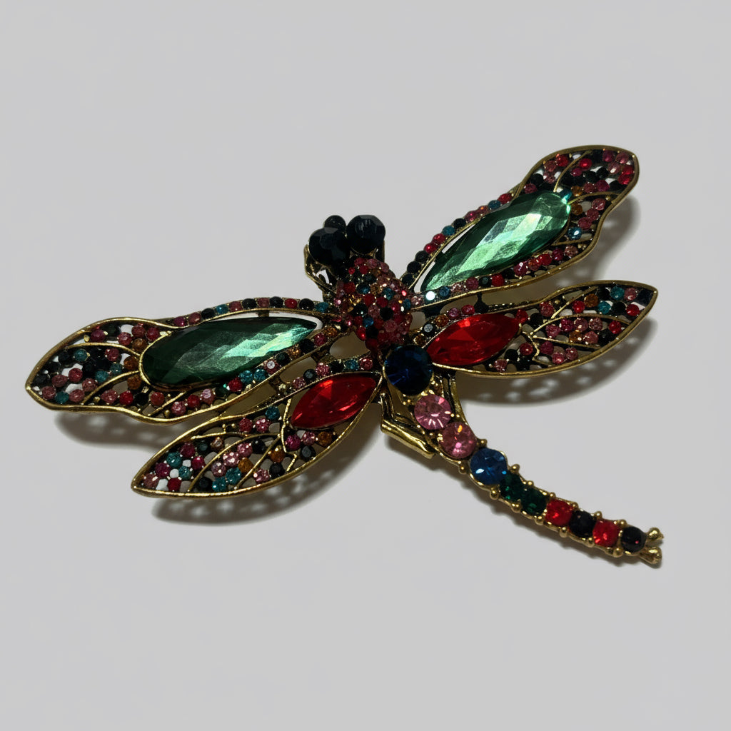 Decorative dragonfly brooch with gemstones on a gray background