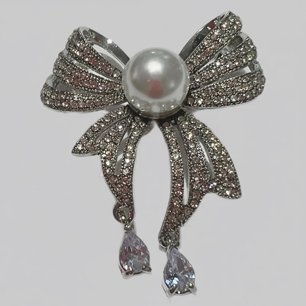 Jewelry brooch with a pearl and crystals on a gray background