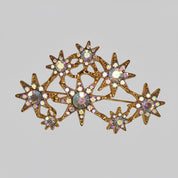 Star-shaped brooch with gemstones on a light gray background