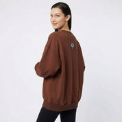 Woman wearing oversized sweat with all seeing eye motif in chocolate brown back view